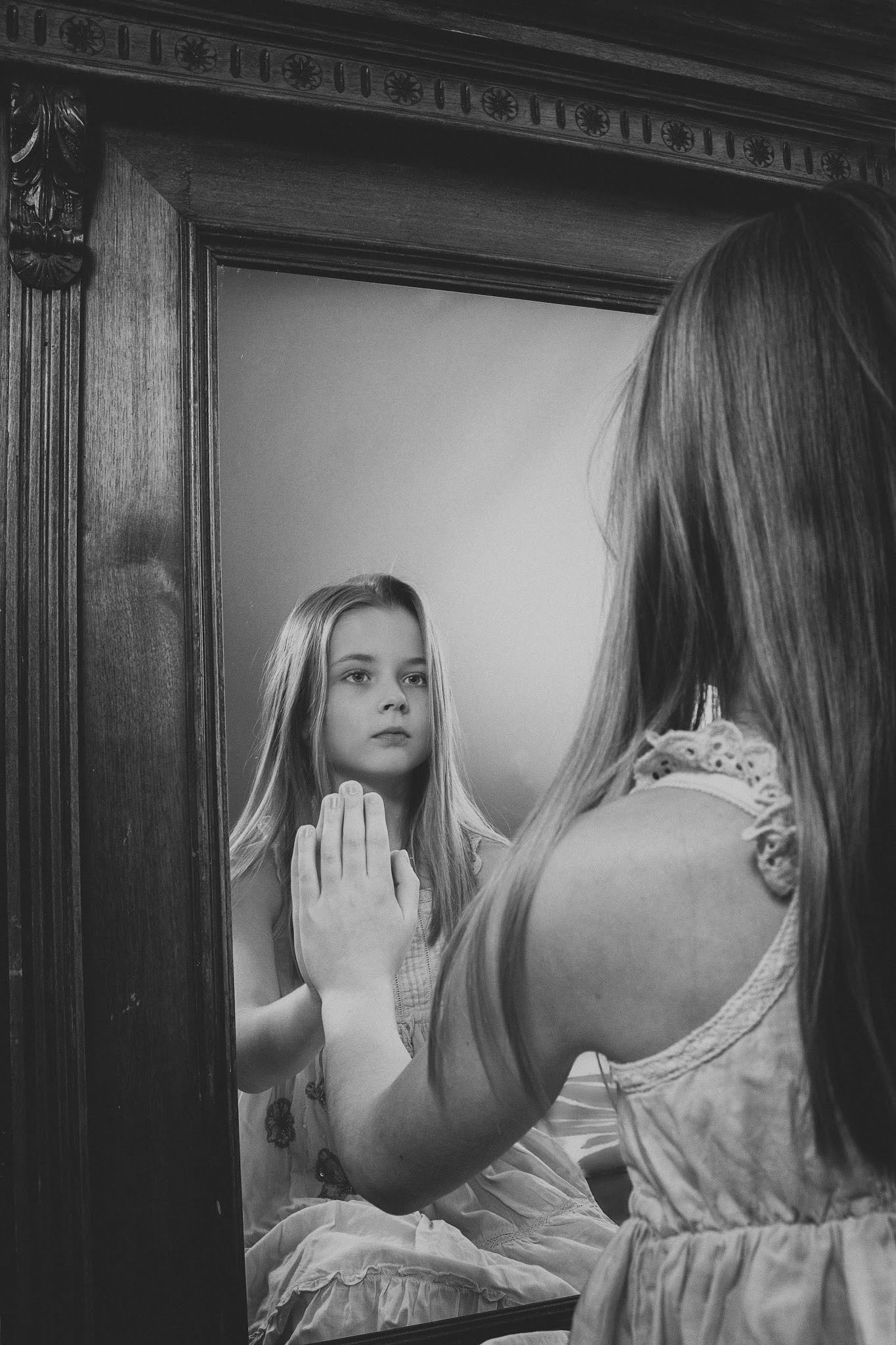 dívka před zrcadlem – černobílý dětský portrét