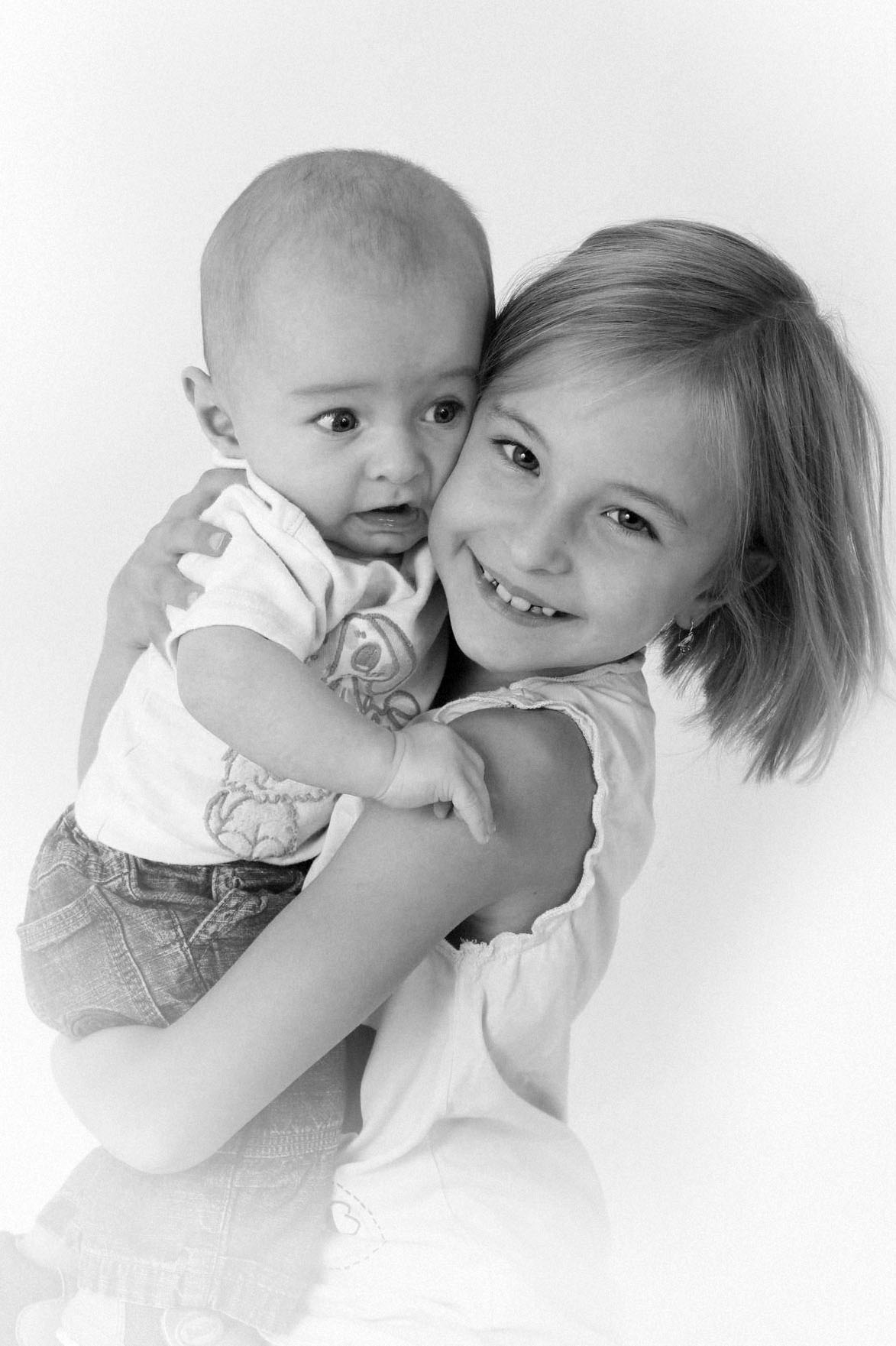 Sourozenci – holčička drží miminko při rodinném focení